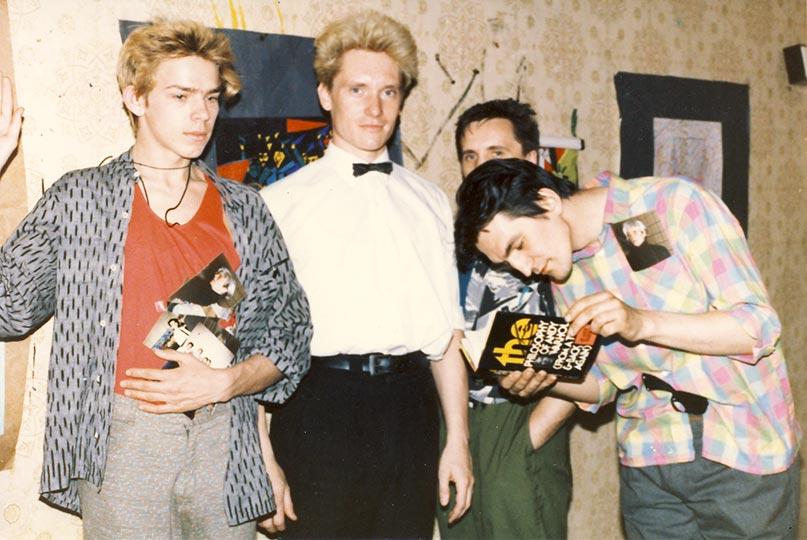 Sergei 'Afrika' Bugaev, Georgy Gurjanov, Oleg Kolomiychuk and Timur Novikov holding a book gifted by Andy Warhol at the ASSA gallery